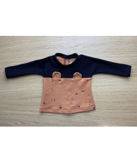 Ce pull est boutonné au dos pour pouvoir l’habiller facilement.