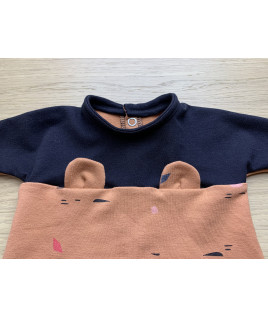 Le devant du vêtement est cousu en tissus noir et orangé